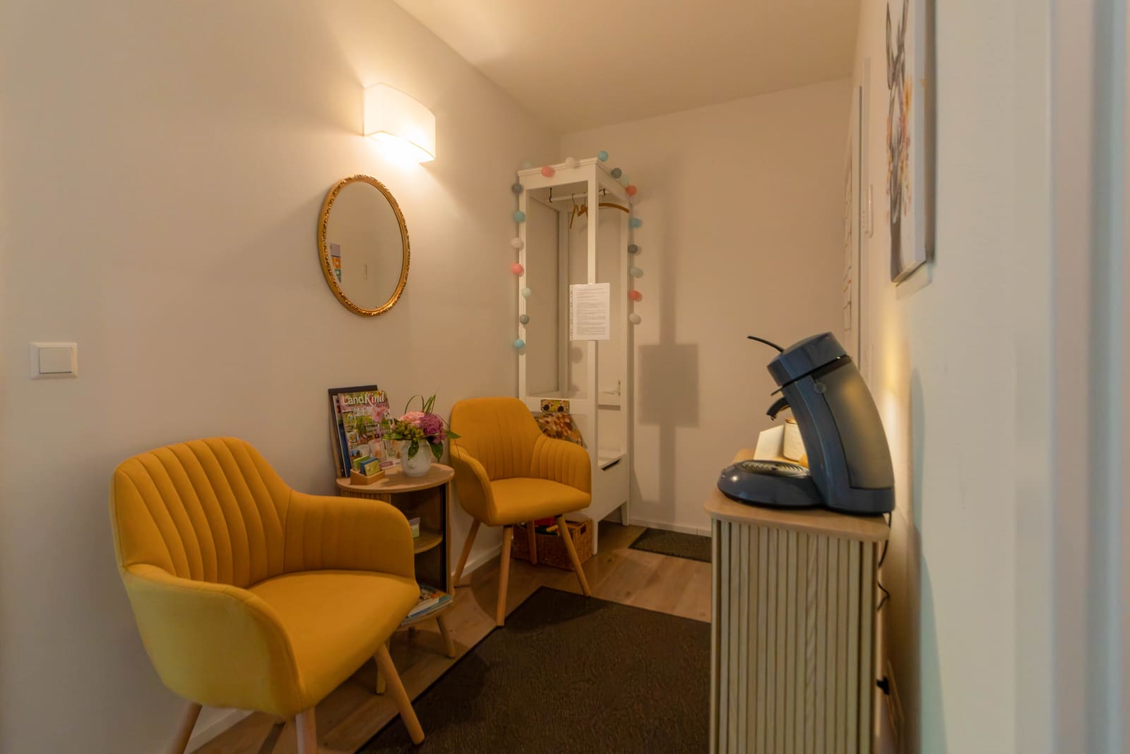 Eingangs- und Wartebereich der Praxis mit Garderobe und Kaffeeecke
